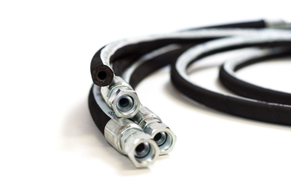 Hydraulic hoses with metal connectors coiled.