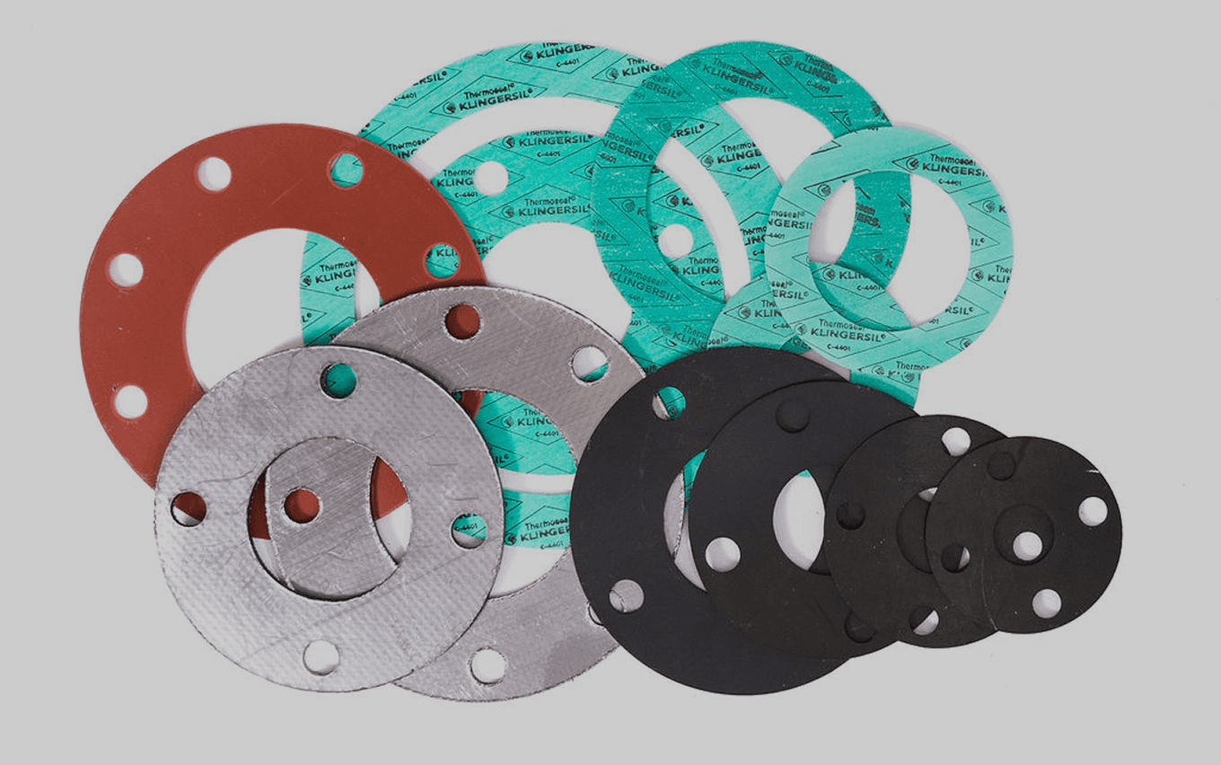 Assorted colorful industrial gaskets on gray background.